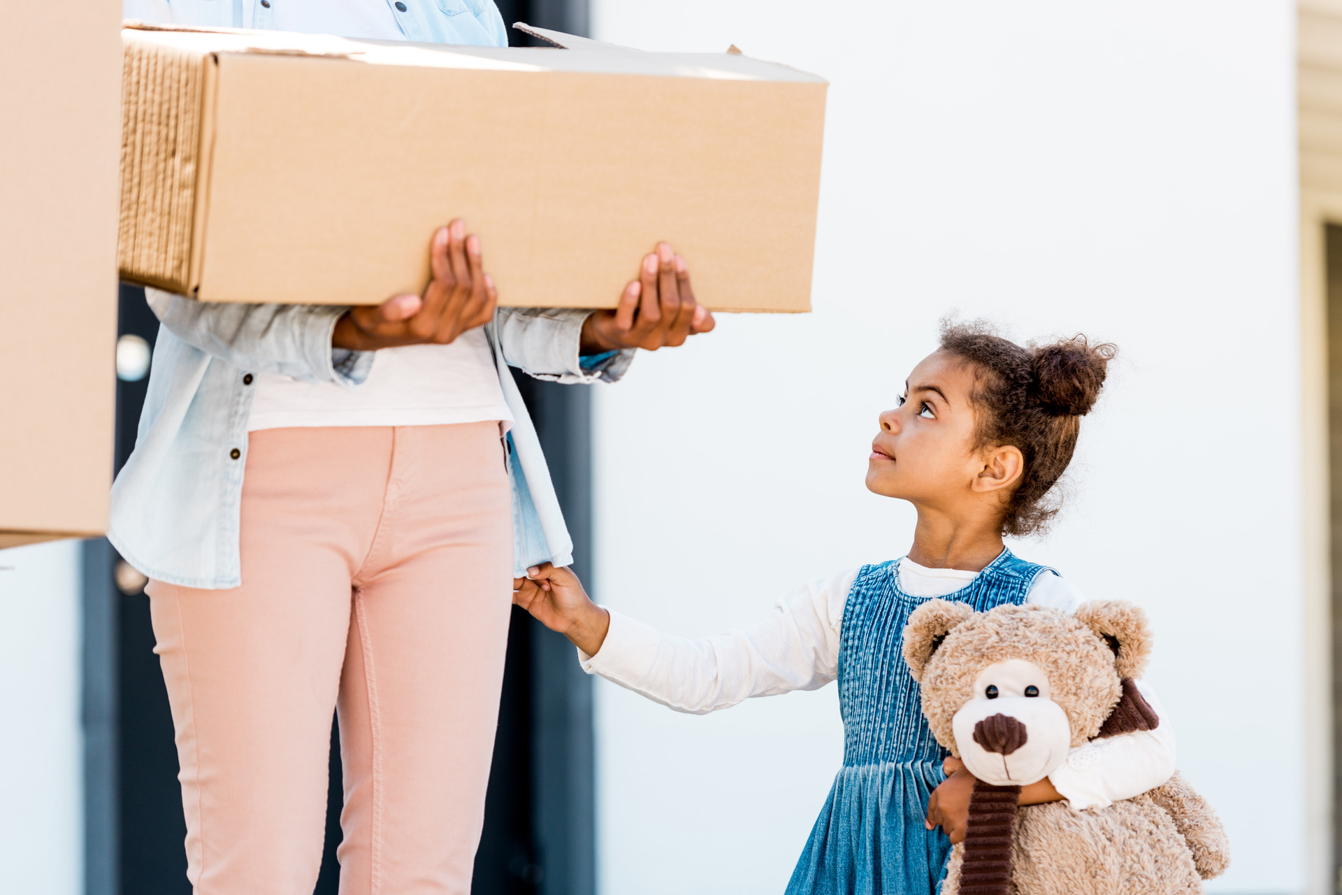 woman holding box while kid stands next to
