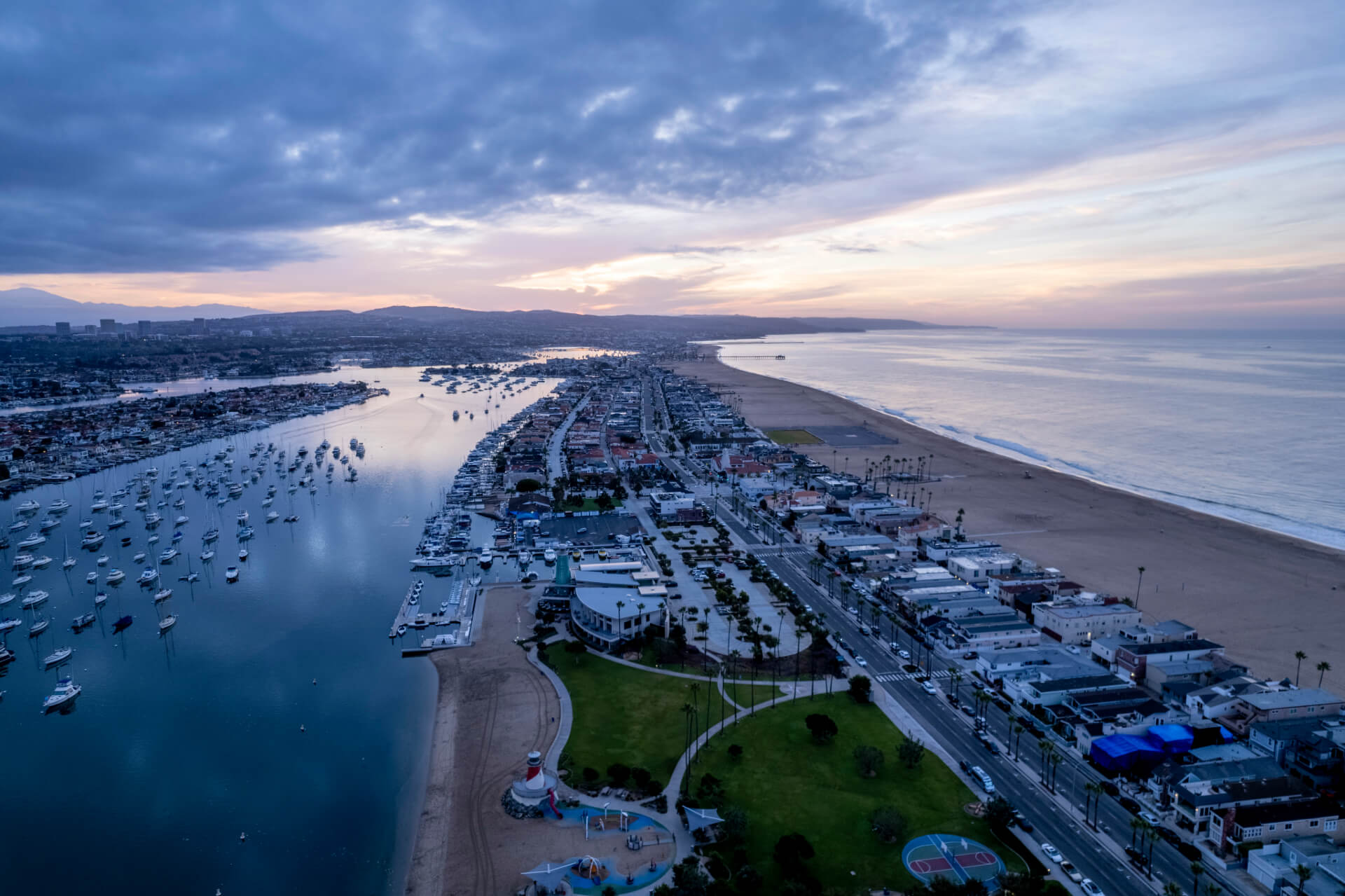 A scenic aerial view of Newport Beach, California, at sunset, showcasing the coastline, marina, and cityscape, representing the area served by a Newport Beach divorce lawyer.