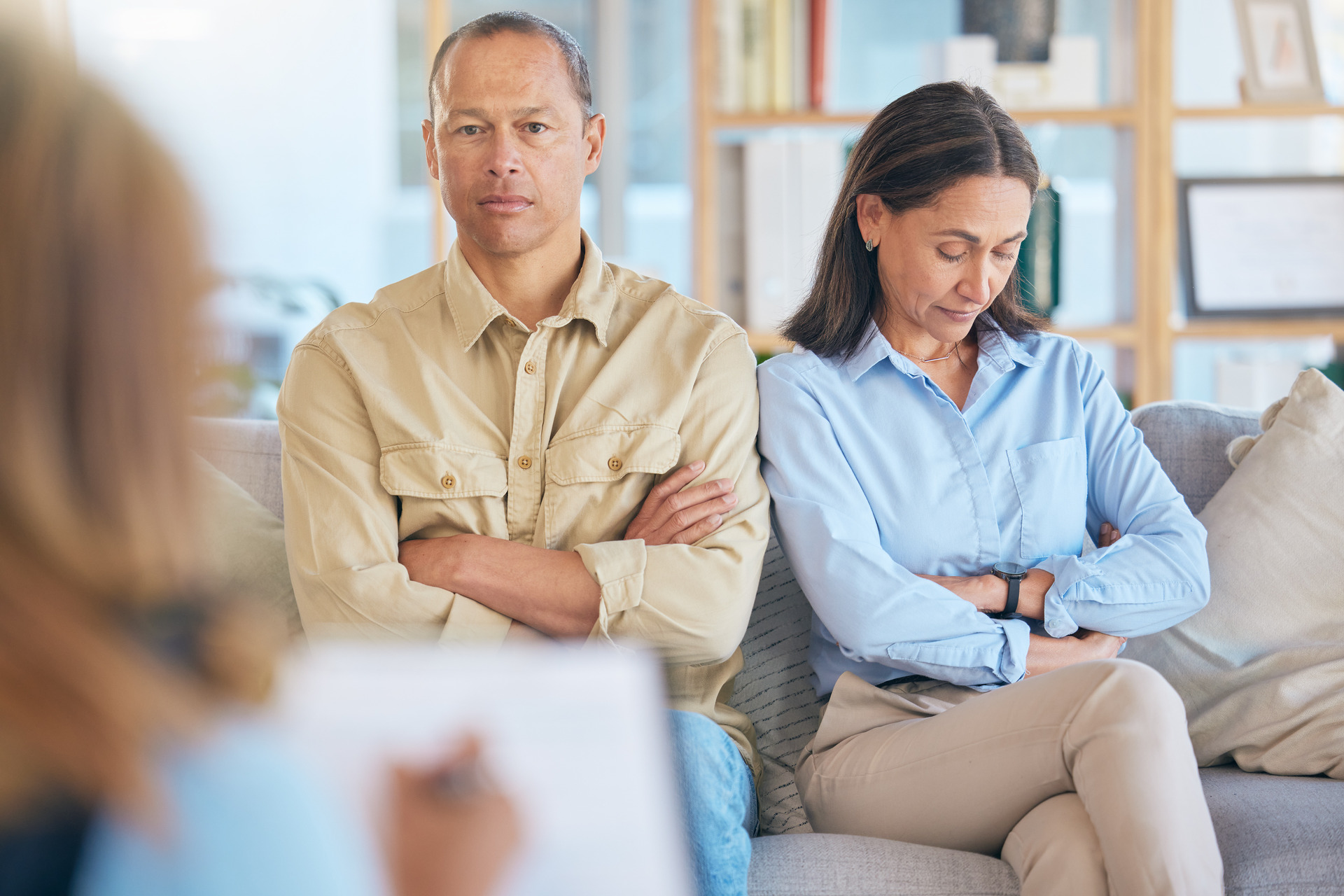 Unhappy-couple-sitting-with-arms-crossed-during-a-counseling-session.-Fullerton-Divorce-Lawyer-providing-legal-support-for-divorce-and-separation-cases