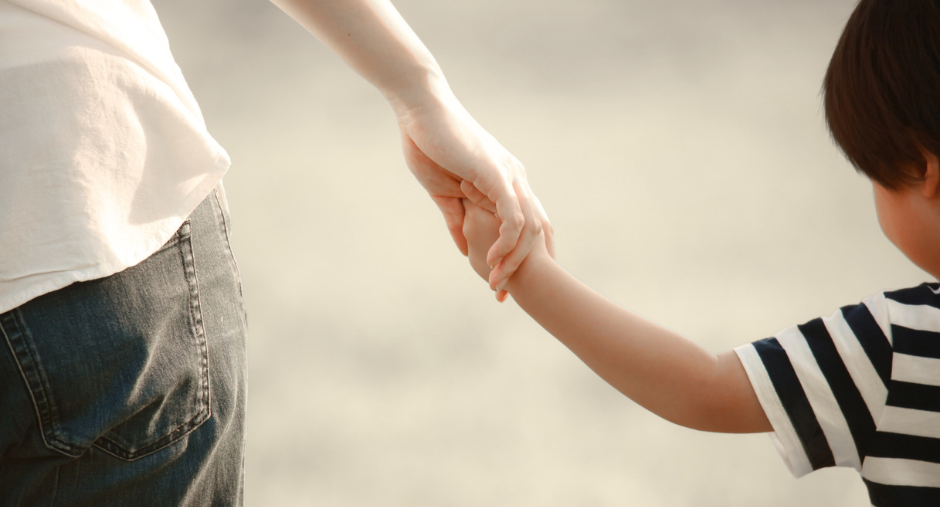a child and a parent holding hand