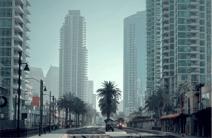 San Diego, California, downtown street with high-rise buildings, palm trees, and light rail tracks.